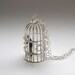 silver bird cage necklace with tiny business man
