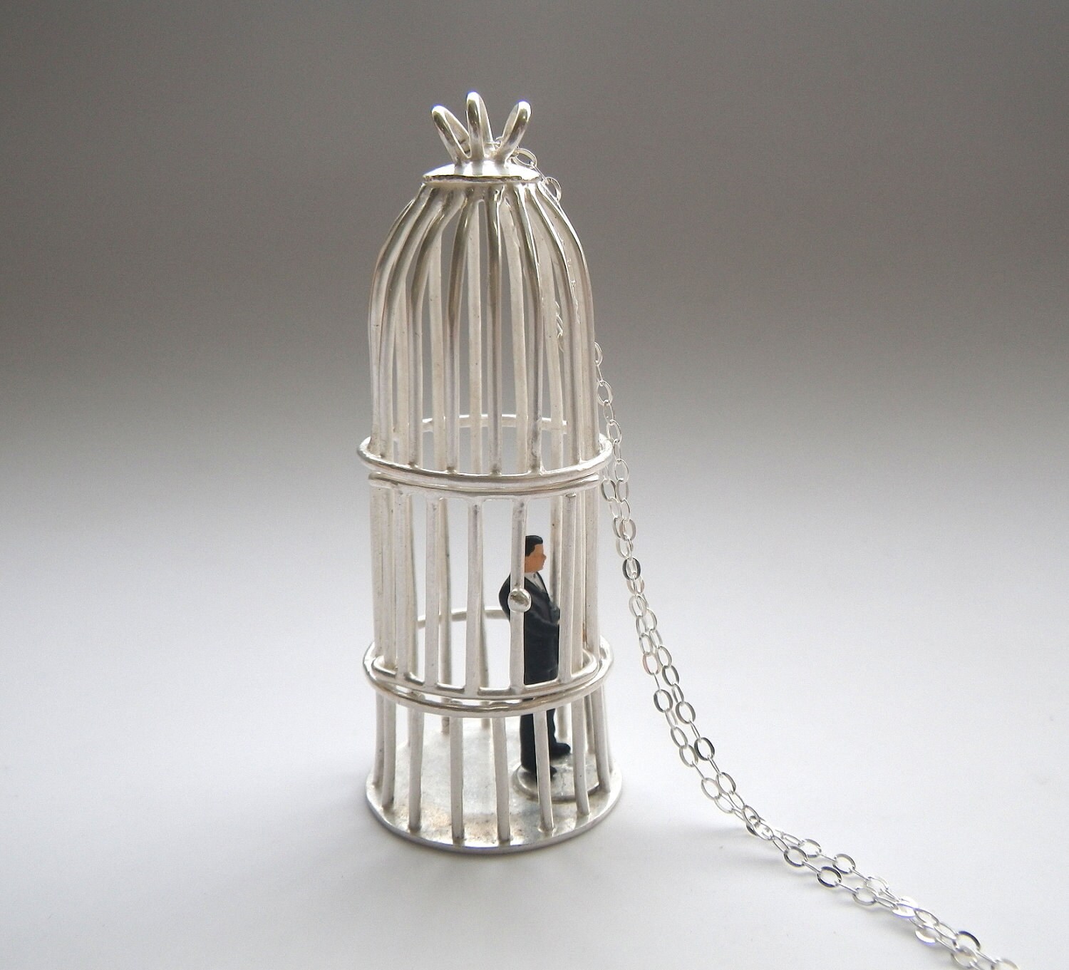 silver bird cage necklace with tiny business man sterling