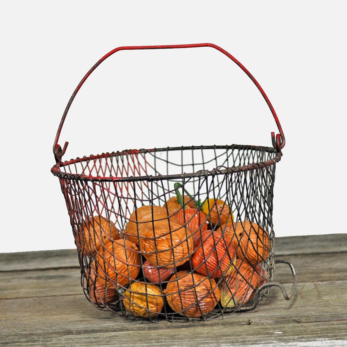 Red wire basket of plastic chestnuts by upscaleyardsale on Etsy
