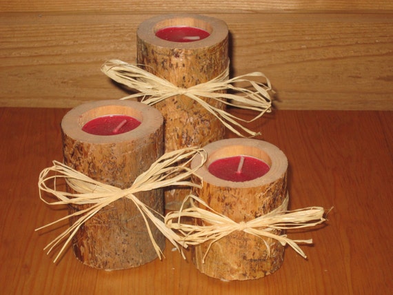Set of 3 pine tealight candle holders with tan raffia accents.