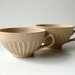 A Pair of Teacups in Dappled Cream-White with Blue Dots, Set of Two by Cecilia Lind, StudioLind