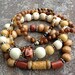 Beaded stretch bracelet set featuring 6mm Tiger's Eye beads, amber Czech beads, and various wooden beads.