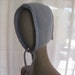 Knitted Bonnet with I-cord Tie in pale blue and faint pink accents