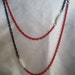 Long blue and red chain necklace with white resin beads