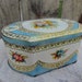 Vintage biscuit tin in baby blue and roses trunk style.