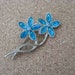 Aqua blue vintage flower pin with rhinestone center in silvertone setting. Vintage brooch