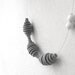 grey minimal geometric necklace with circles and two white dots