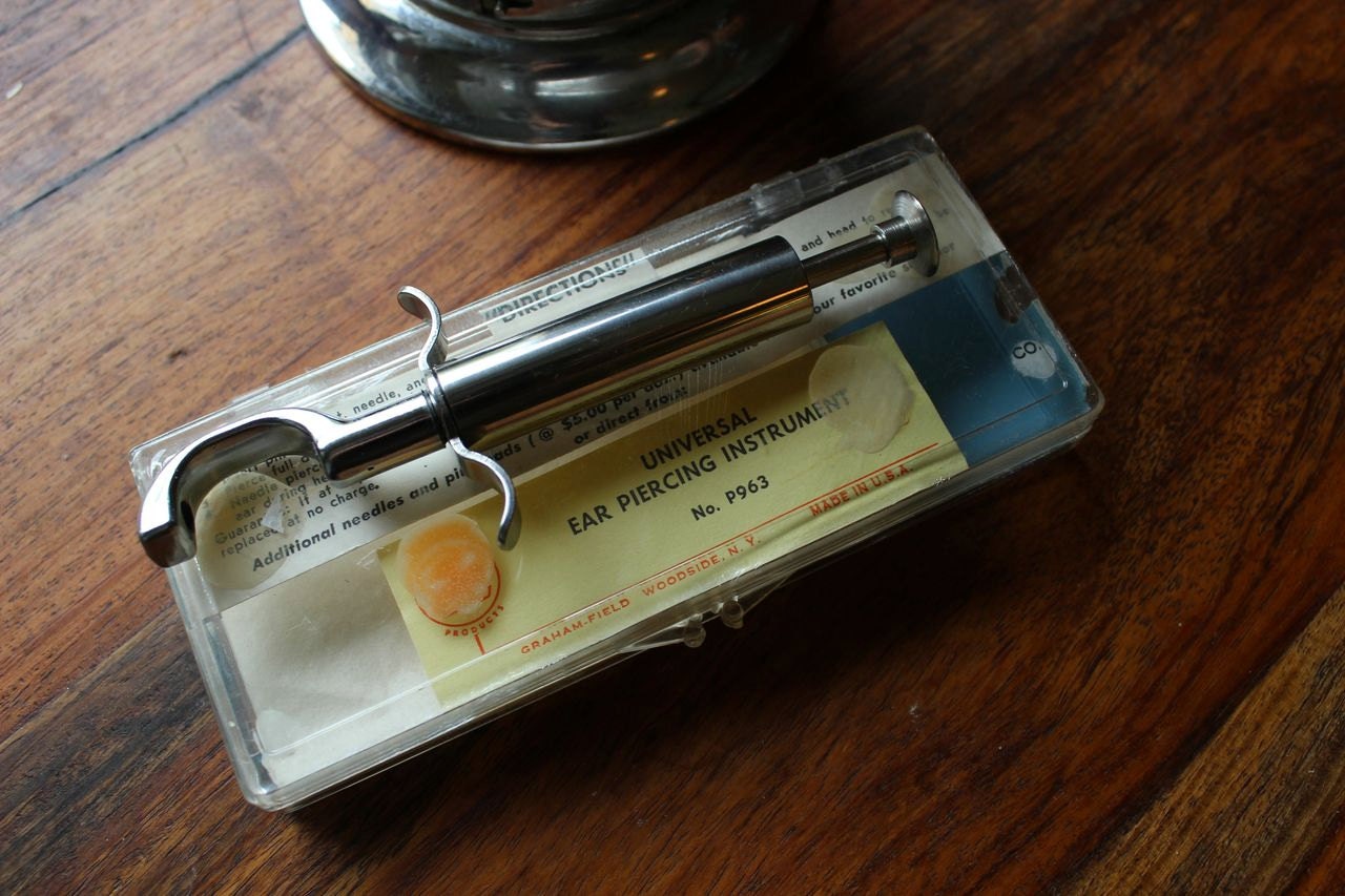 Vintage medical ear piercing instrument and gauze dispenser
