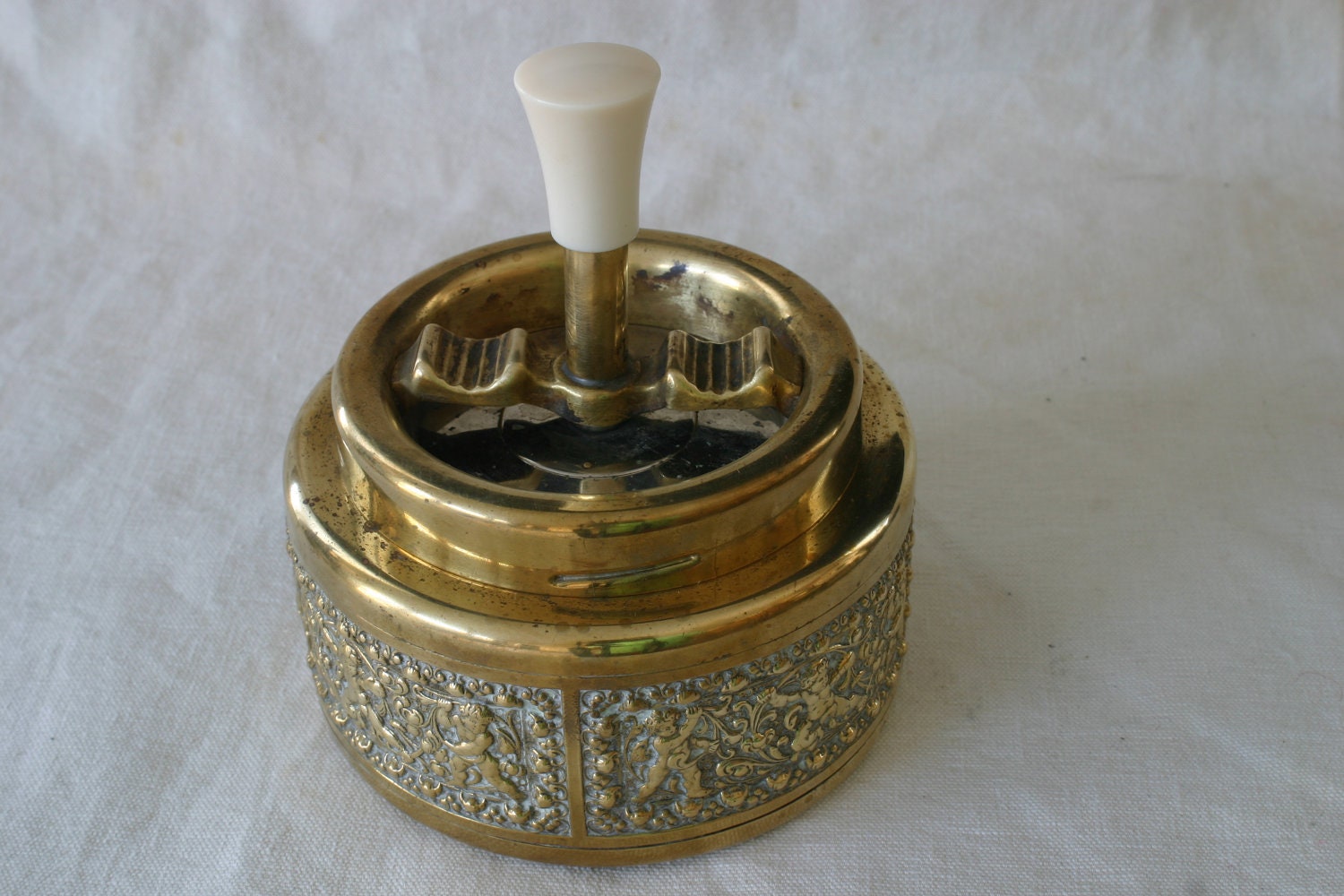 Vintage German brass spinning ashtray featuring a neoclassical