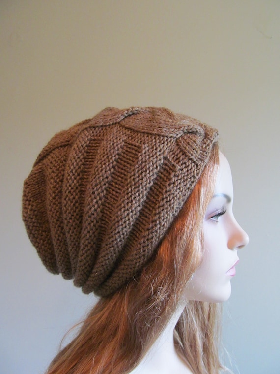 FIND IN A STORE Slouchy Knit Beanie. Women's pink hand knitted cable hat. Slouchy hat. About: This soft and classic looking hat/beanie is so fashionable. It has been knit by hand with a gorgeous yarn that is made from 50% lambswool and 50% cotton.