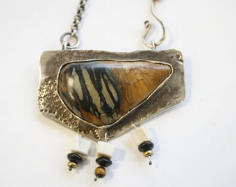 Varigated petrified agate pendant backed on hammered silver Melinda Salazar