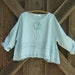 linen top flare with ruffle, tucking and a rose in light blue