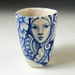 Blue and white hand painted porcelain cup with faces