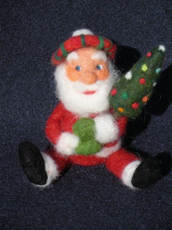 Needle felted Santa Claus wearing a plaid beret and holding a