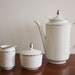White porcelain tea set includes tea pot, sugar and creamer
