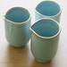 Set of 3 Wheel Thrown Porcelain handle-less pitchers with blue delicate glaze and gold rims