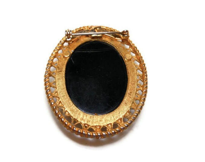 Glass cameo brooch on black glass with gold tone filigree frame