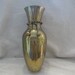 Large brass vase with brass rope and balls around it