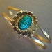 Egyptian revival.Vintage 80s goldtone metal hinged cuff bracelet with green scarab.