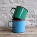 antique c. 1920s pair of enamel mugs with Dutch scenes