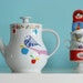 Medium/large-sized bird, apples and polkadot dress teapot
