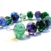 Handmade lampwork glass bead set of multicoloured 12 renegade beads - predominantly green and purple lampwork orphan beads