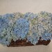 Dried Blue Hydrangea Arrangement In A Brown Wicker Basket Accented With Blue Globe Thistle