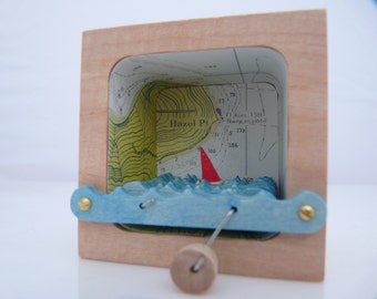 Kinetische houten boot sculptuur met zeekaarten