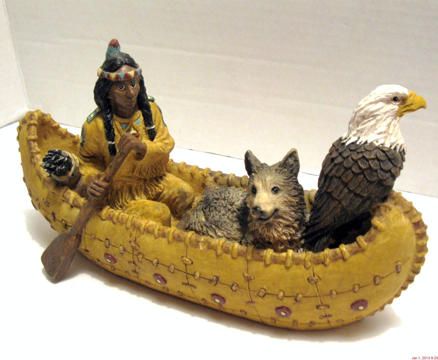 native american indian in canoe with wolf & eagle figurine