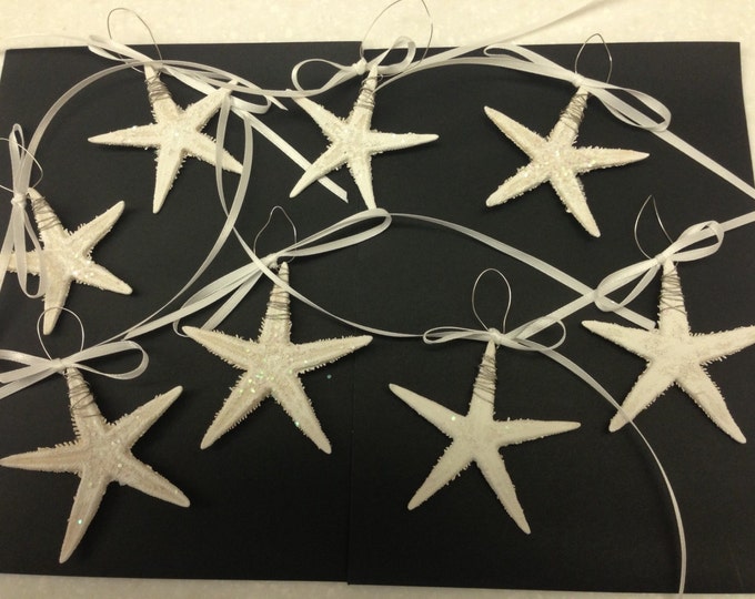 8 Actual Mini Starfish. Painted White with a touch of Glitter, wire wrapped and an addition of Ribbon.