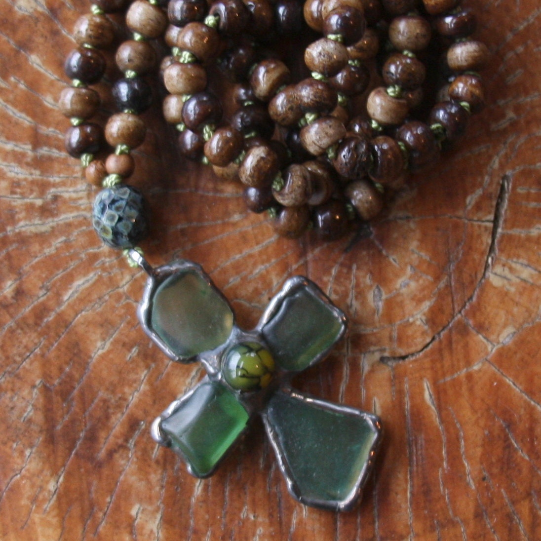 green sea glass cross on brown bone beads from a prayer