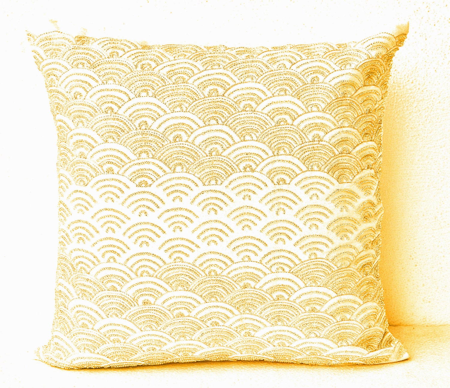 Cream throw pillows with detailed embroidered waves Gold
