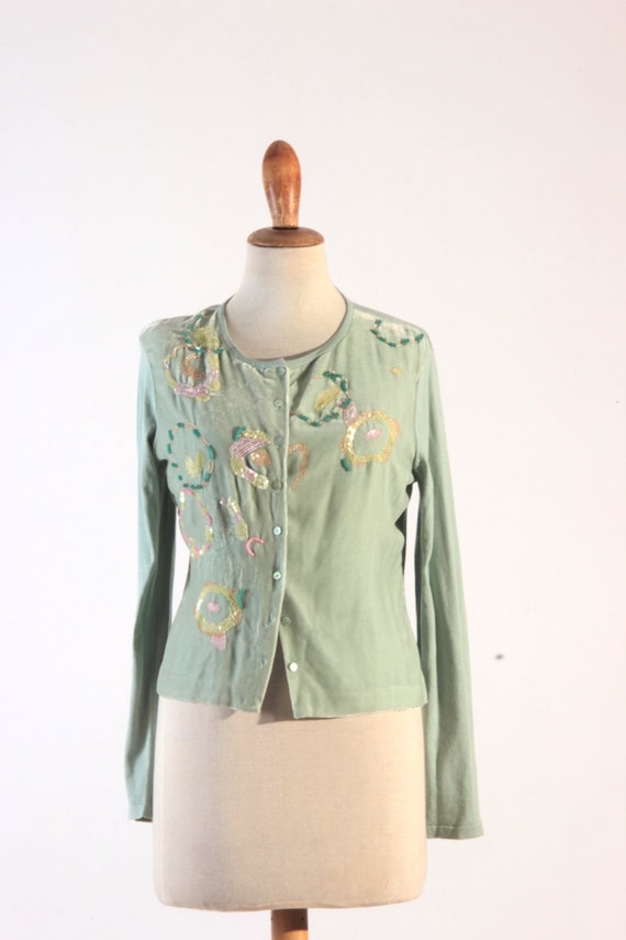 Mint color sweater With mint it’s always better to wear a piece of clothing or accessory which would perfectly match it in terms of color – and that is usually mint! This outfit idea features mint green pumps with floral printed midi and navy purse, but the print of the skirt has some mint in it and the ruffled top is also of mint color.