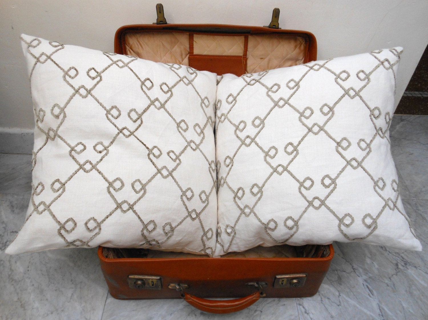 2 white linen cushion covers with a lozenge pattern