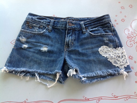 Items similar to Cut-off jean shorts with hand sewn lace embellishment ...