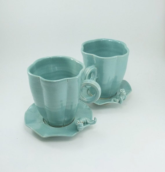 pair of cups and saucers with frog and caterpillar