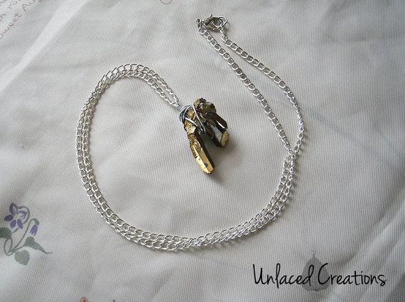 edrys. a wire-wrapped gold titanium quartz pendant on silver chain.
