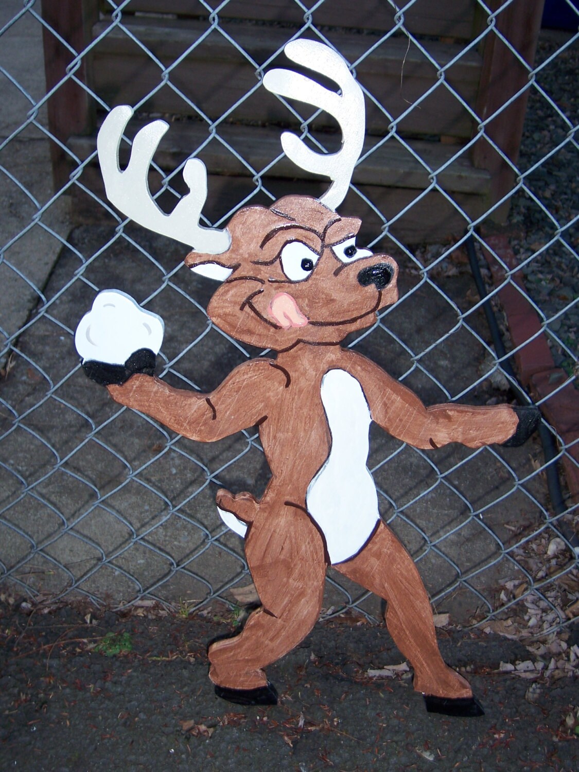 Handmade custom painted wooden reindeer throwing a snowball for your yard