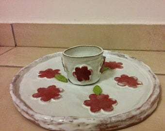 A clay handmade white serving plate with a dipping glass