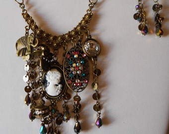 Steampunk Necklace with a Boho influence. Black and white cameo, selected charms,brass drop chain,Swarovski rivoli,and assorted crystal.