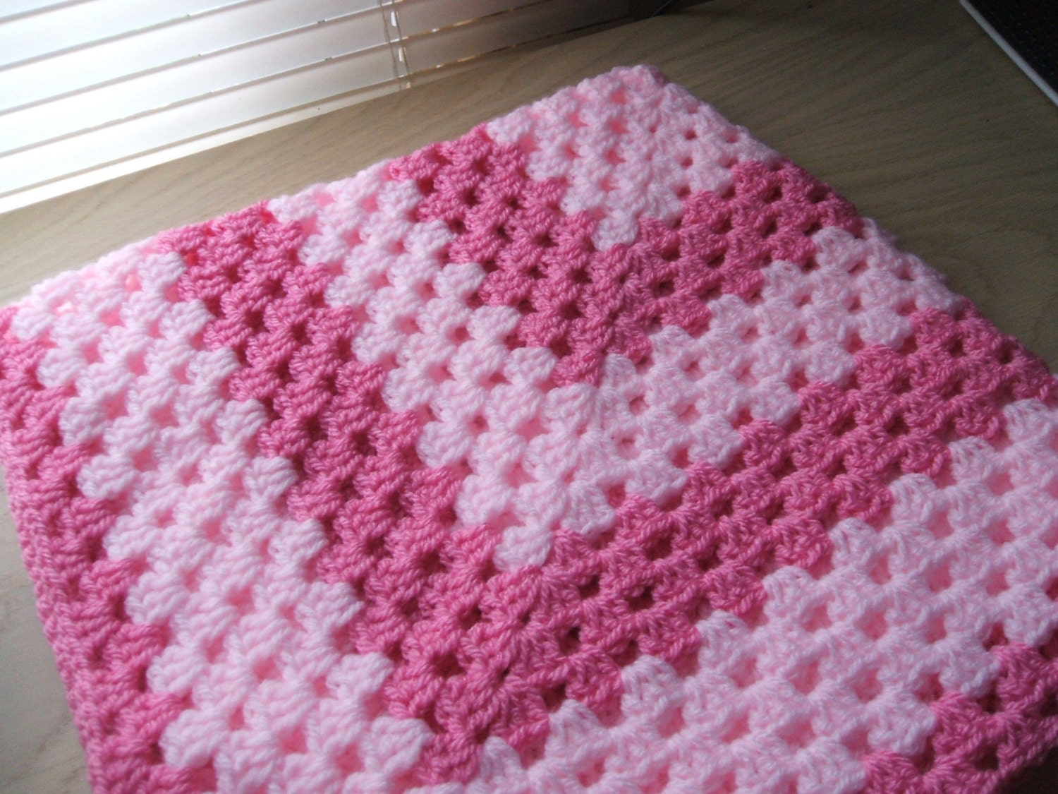 Hand crocheted baby blanket. Pale and deep pink. Suitable for