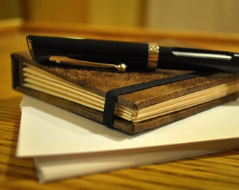 Faux leather portfolio book with accordion pockets and black elastic