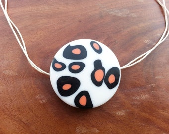 pretty white black and orange spotty pendant