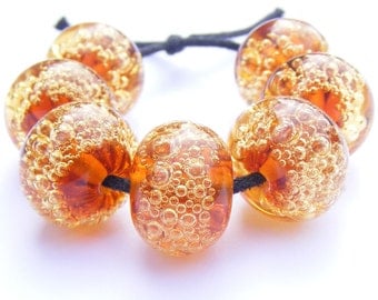 Handmade lampwork bead set of 7 coppery orange and amber glass bubble beads