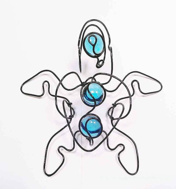 Blue is a beautiful three dimensional continuous wire sculpture sea turtle with colorful light blue glass gems.