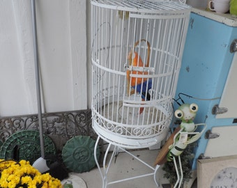 Vintage wrought iron birdcage on stand.