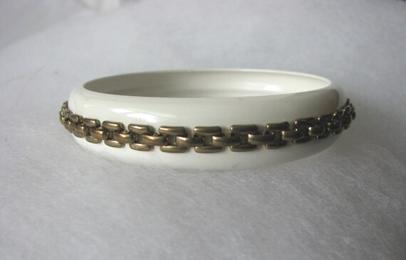 White metal bangle bracelet with gold tone geometric accent design