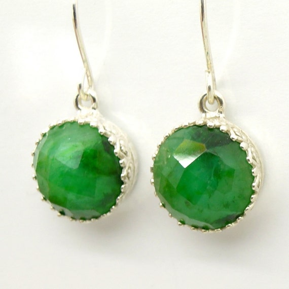 Emerald earrings set in silver around gemstone