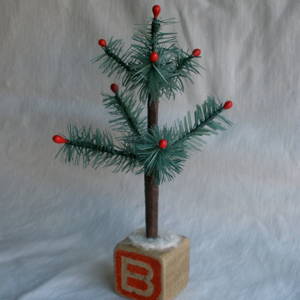 Blue spruce 7 branch feather tree, 8.5" inches tall, it comes in a white, or a mossy green color. With or without candles. Vintage base.