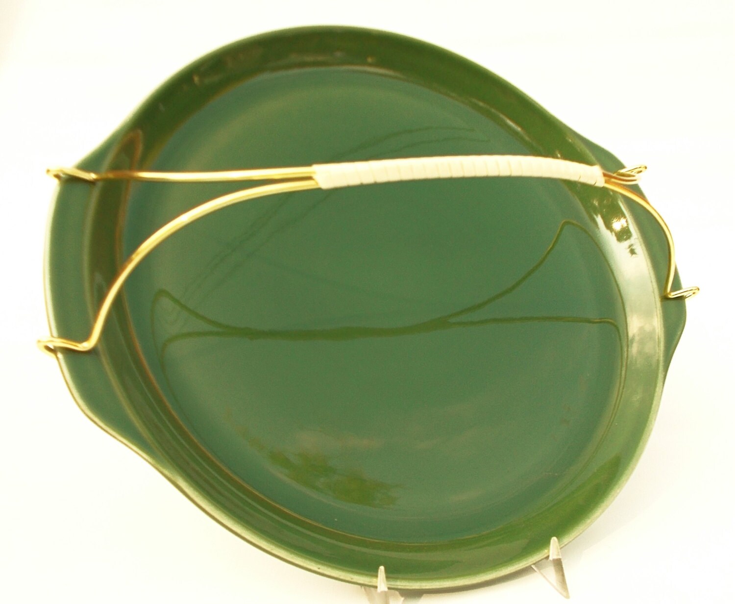 Green ceramic serving tray with brass handle and white vinyl